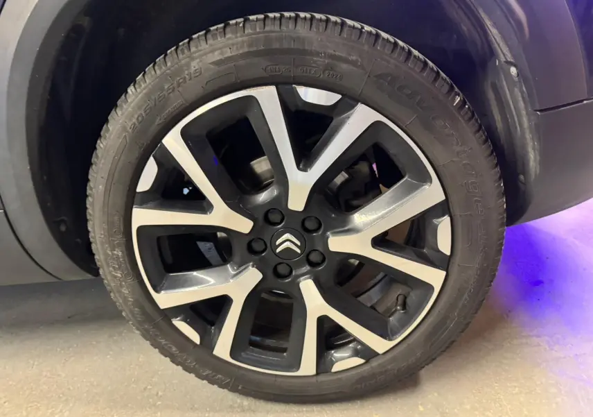 Vue 3/4 arrière droite d'un Citroën C5 Aircross bleu avec feux arrière LED allumés et jantes alu 18 pouces.