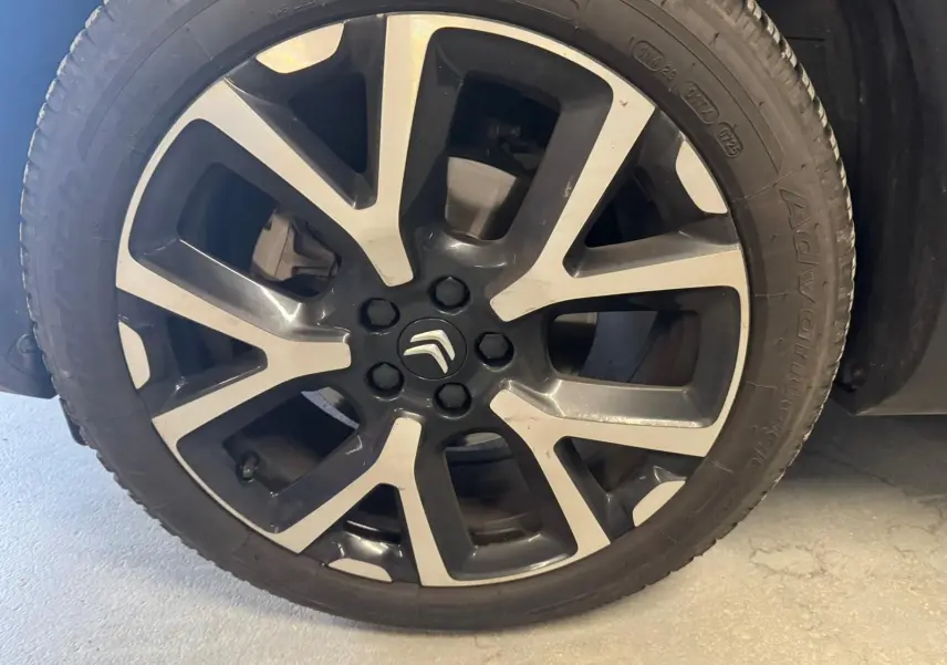 Gros plan sur une jante alu 18 pouces bicolore avec logo Citroën au centre, montée sur un pneu noir.