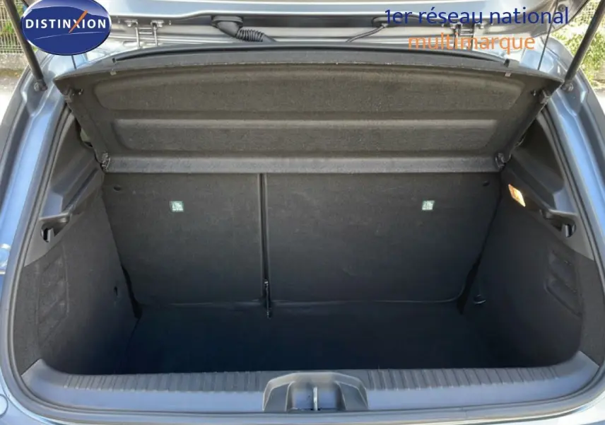 Coffre ouvert vu de l'arrière d'une Renault Clio 2025 gris schiste métal, espace de chargement vide et propre.