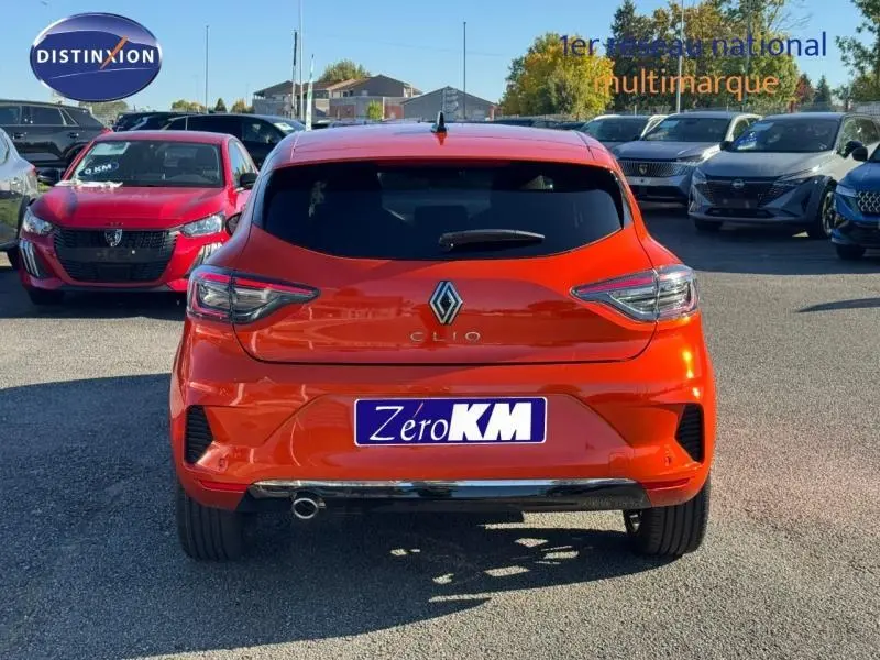 Vue arrière d'une Renault Clio orange Valencia 2025 avec feux LED et plaque d'immatriculation Zero KM visible.