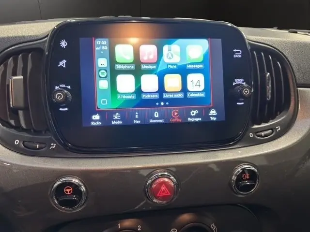 Écran tactile central allumé avec interface Apple CarPlay sur tableau de bord gris foncé de Fiat 500 2022.