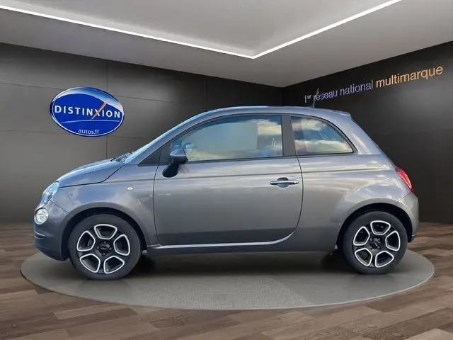 Profil droit d'une FIAT 500 gris foncé 2022, compacte avec jantes alliage et toit fermé dans un showroom.