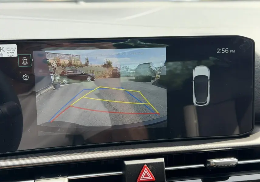 Écran tactile du Kia Sportage blanc montrant la caméra de recul avec lignes de guidage dynamiques.