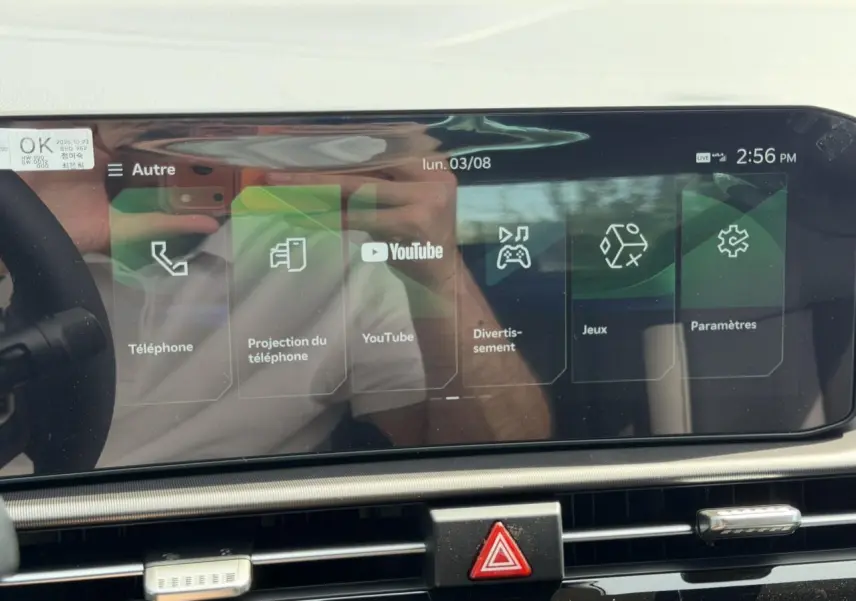 Écran tactile 12,3'' du Kia Sportage 2026 blanc, affichant menu multimédia avec YouTube et téléphone.