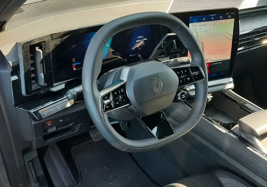 Vue intérieure du poste de conduite du Renault Austral E-Tech gris schiste, avec volant multifonction et écran tactile vertical.