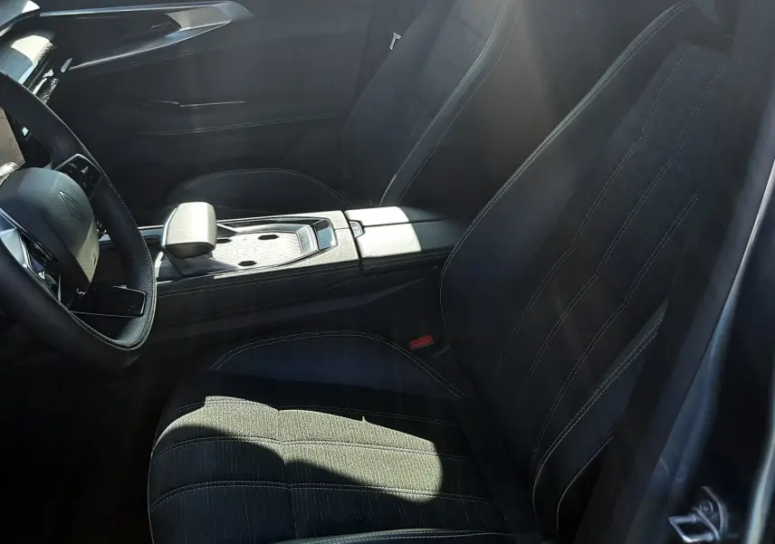 Intérieur noir du Renault Austral 2025, vue côté conducteur, avec sièges en tissu et console centrale moderne.