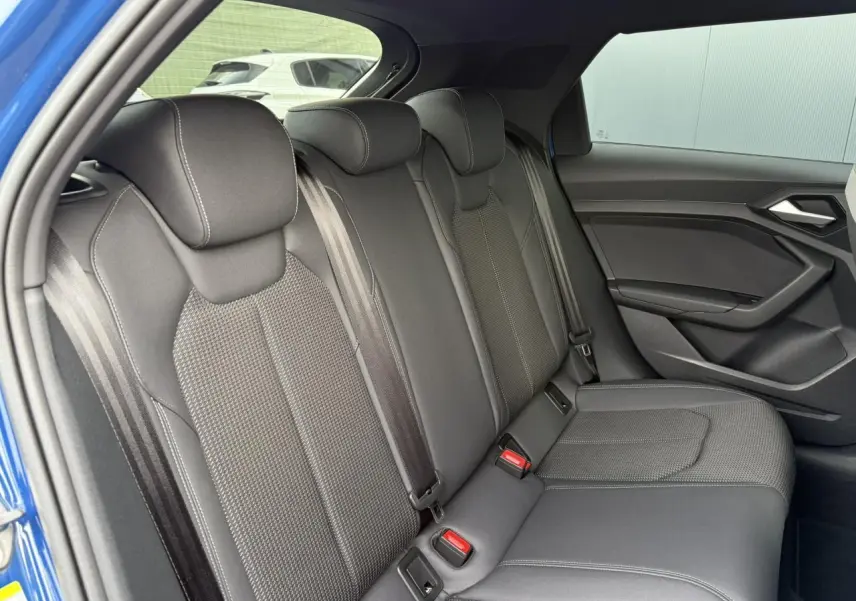 Vue côté droit des sièges arrière noirs en cuir et tissu de l'Audi A1 Sportback Bleu Ascari 2023 avec porte ouverte.
