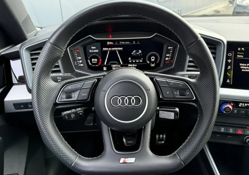 Volant sport cuir perforé avec logo S line de l'Audi A1 Sportback 30 TFSI 110 S-Tronic Competition, tableau de bord numérique visible.