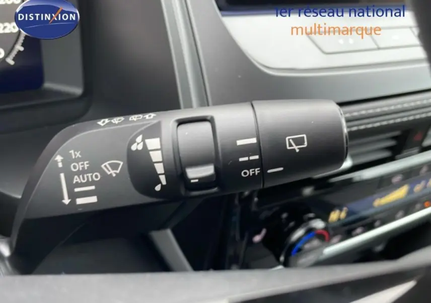 Gros plan sur la commande des essuie-glaces du Nissan Qashqai blanc 2025, intérieur moderne avec écran tactile.