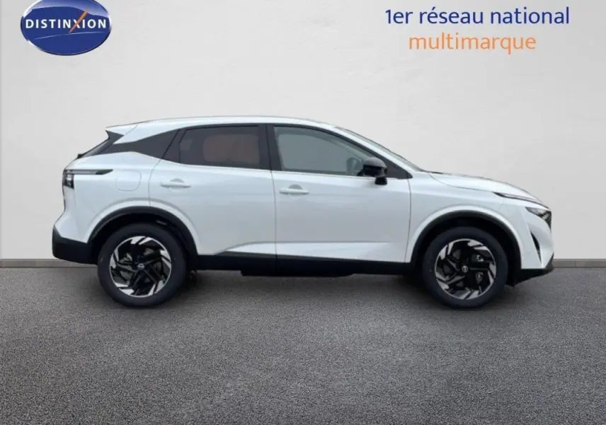 Vue de profil côté gauche du Nissan Qashqai blanc 2025 avec jantes aluminium et barres de toit visibles.