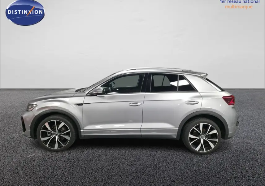 Vue de profil côté gauche d'un Volkswagen T-Roc gris métallisé avec jantes alliage 19 pouces et finitions R-Line.