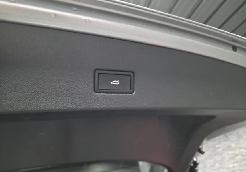 Bouton d'ouverture électrique du hayon sur la face intérieure du coffre du Volkswagen T-Roc gris 2025 R-Line.