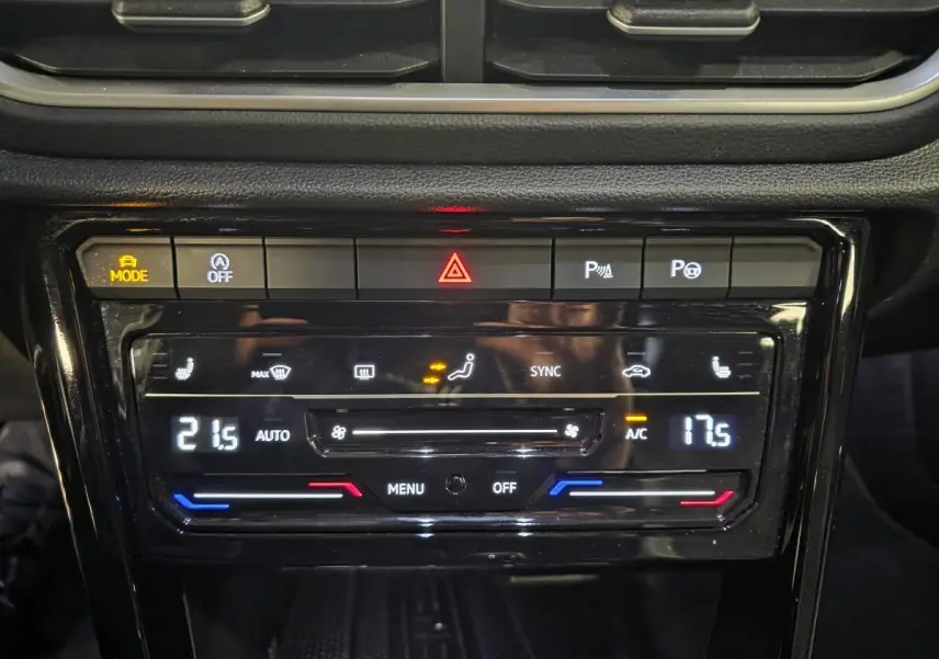 Détail du tableau de bord noir du Volkswagen T-Roc 2025, montrant la climatisation automatique bi-zone et commandes tactiles.