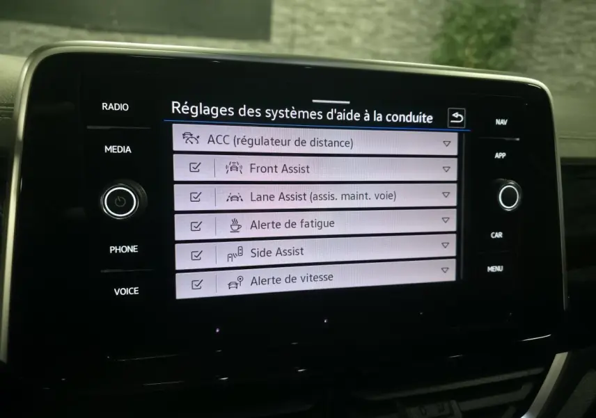 Écran tactile intérieur du Volkswagen T-Roc 2025 affichant les réglages des aides à la conduite.