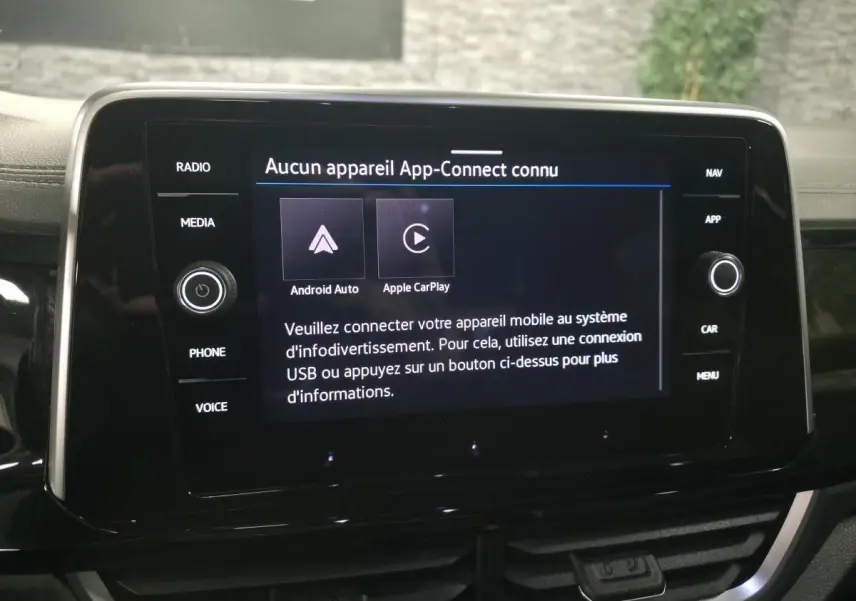 Écran tactile central noir affichant le menu App-Connect dans l'habitacle du Volkswagen T-Roc gris.
