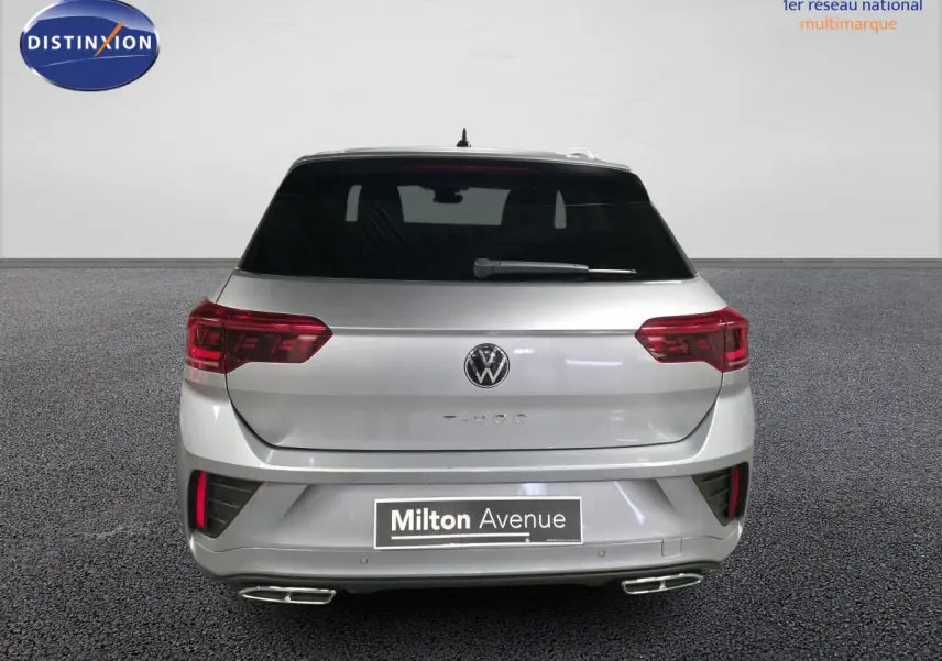 Vue arrière d'un Volkswagen T-Roc gris métallisé 2025 avec feux LED et double sortie d'échappement chromée.