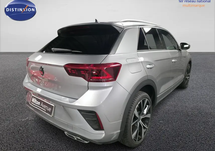 Vue 3/4 arrière droite d'un Volkswagen T-Roc gris métallisé avec jantes alliage 19 pouces et détails R-Line.