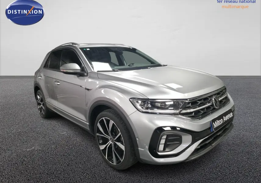 Vue 3/4 avant droit du Volkswagen T-Roc gris métallisé R-Line avec jantes alliage 19 pouces et calandre spécifique.