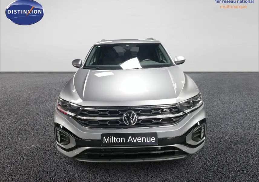 Vue frontale d'un Volkswagen T-Roc gris métallisé avec calandre R-Line et plaque Milton Avenue.