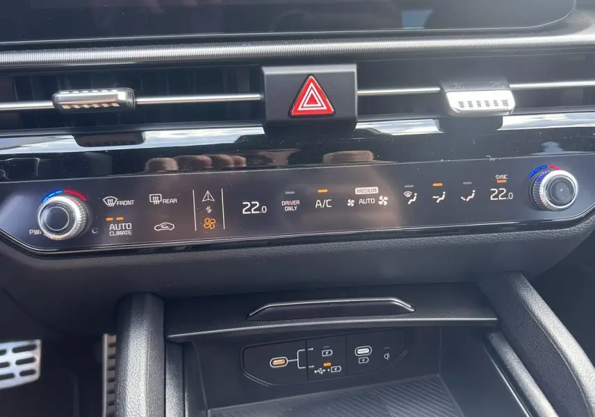 Gros plan sur la console centrale noire du Kia Sportage 2026, affichant la climatisation automatique et les commandes tactiles.