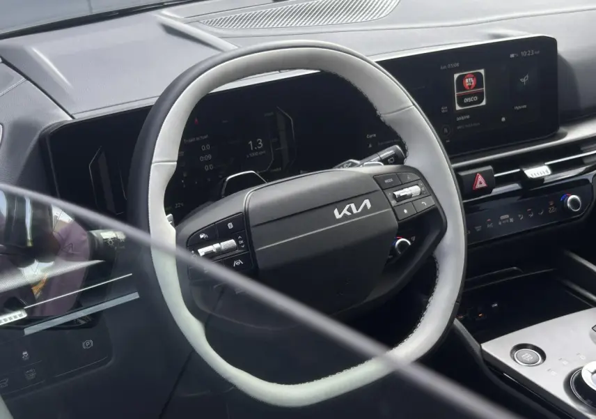 Vue intérieure du volant bi-ton noir et gris du Kia Sportage 2026 avec tableau de bord digital et écran tactile.