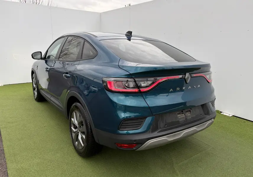 Vue 3/4 arrière droite d'une Renault Arkana 2025 bleu Zanzibar métal avec feux arrière LED et vitres surteintées.