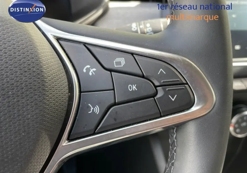 Gros plan sur les commandes multifonctions à droite du volant en cuir noir de la Renault Clio gris schiste 2025.