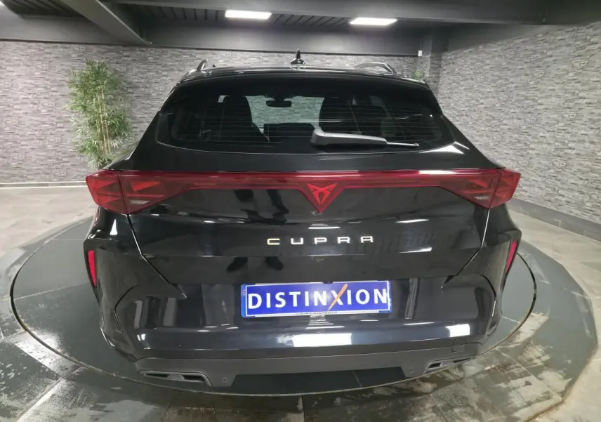 Vue arrière d'une CUPRA Formentor noire 2025 avec bandeau lumineux et double sortie d'échappement intégrée.