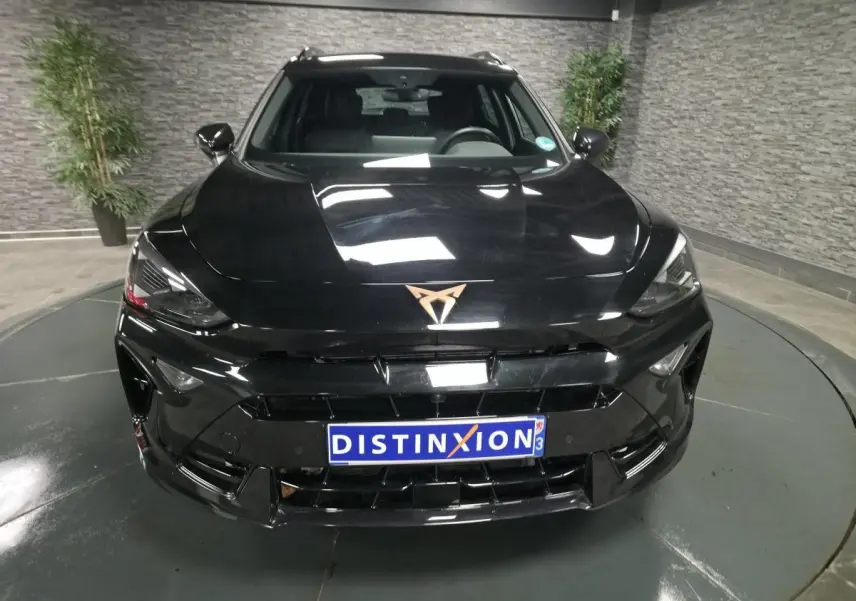 Vue avant d'une CUPRA Formentor noire 2025 avec logo cuivre et calandre imposante dans un showroom.