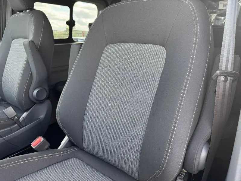 Gros plan sur les sièges avant gris à tissu rayé du Volkswagen Transporter Procab 2025, vue intérieure côté droit.