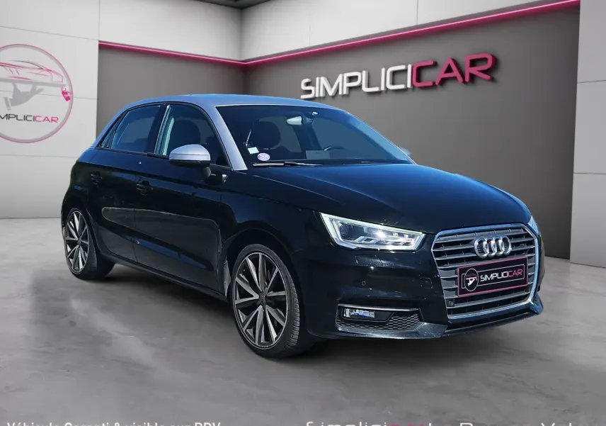 Audi A1 Sportback noir vue 3/4 avant droit, avec jantes alliage 17 pouces et phares LED allumés.