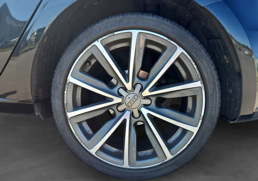 Gros plan sur la jante alliage 17 pouces de couleur argentée de l'Audi A1 Sportback noire, côté arrière droit.