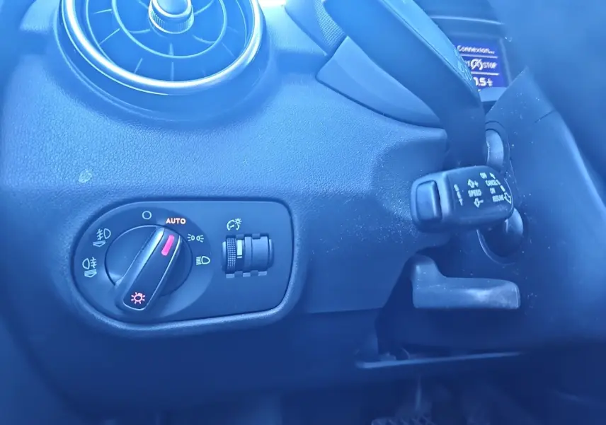 Détail du tableau de bord noir de l’Audi A1 Sportback 2016, avec commande d’éclairage et aérateur rond visible.
