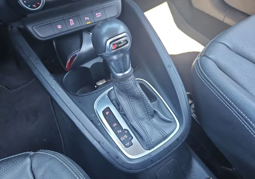 Gros plan sur la console centrale noire de l'Audi A1 Sportback 2016 avec levier de vitesse S tronic et sellerie cuir.