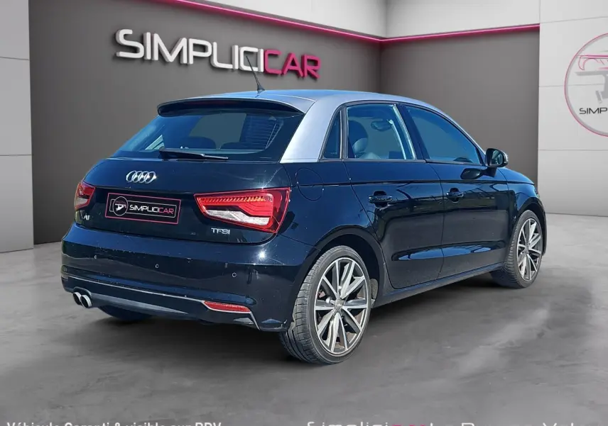 Audi A1 Sportback noir vue 3/4 arrière droit avec toit contrasté gris et jantes alliage 17 pouces.