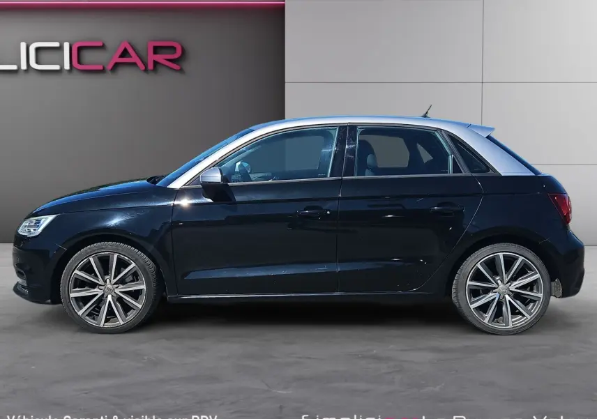 Vue de profil côté gauche d'une Audi A1 Sportback noire avec toit argenté et jantes alliage 17 pouces.
