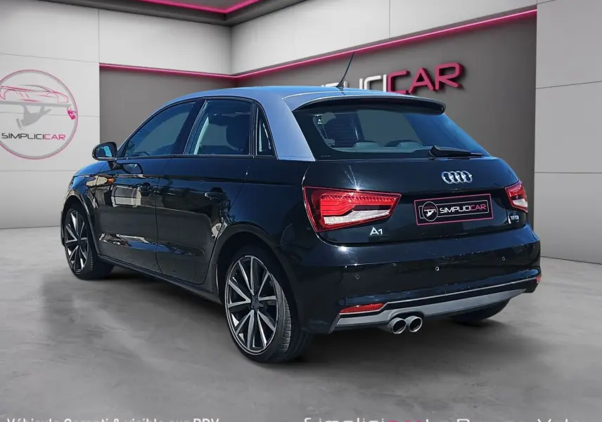 Audi A1 Sportback noir vue 3/4 arrière droit, avec jantes alliage 17” et becquet distinctif.