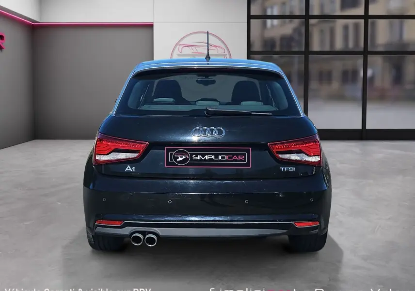 Vue arrière d’une Audi A1 Sportback noire de 2016 avec feux LED et double sortie d’échappement visible.