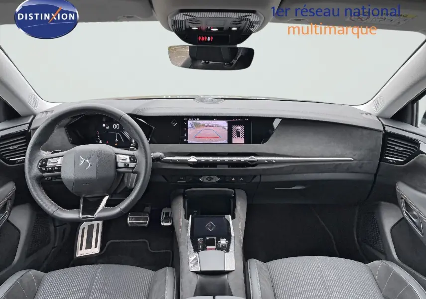 Intérieur du DS4 2024 en vue frontale, tableau de bord moderne avec écran central et volant multifonction noir.