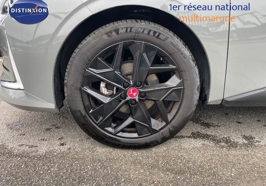 Gros plan sur la roue avant gauche d'une DS4 2024 gris laqué métal avec jante noire au design géométrique.