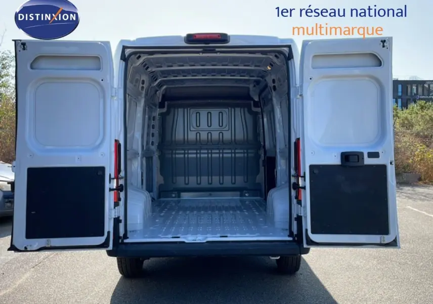 Vue arrière du Peugeot Boxer Fourgon blanc banquise 2025 avec portes ouvertes montrant l'espace de chargement vide.