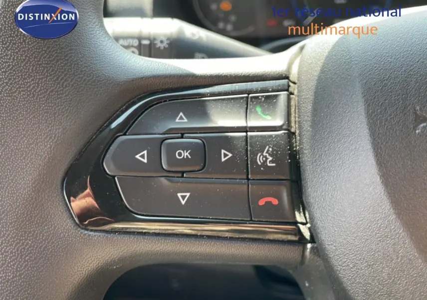 Gros plan sur les commandes multifonctions au volant du Peugeot Boxer Fourgon blanc banquise, version 2025.