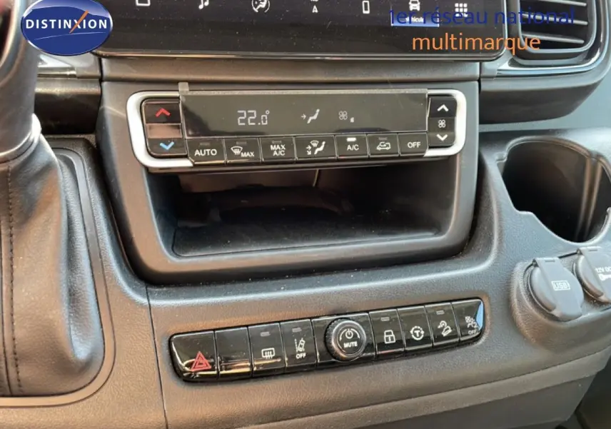 Vue rapprochée de la console centrale du Peugeot Boxer Fourgon blanc, avec commandes climatisation et boutons multifonctions.