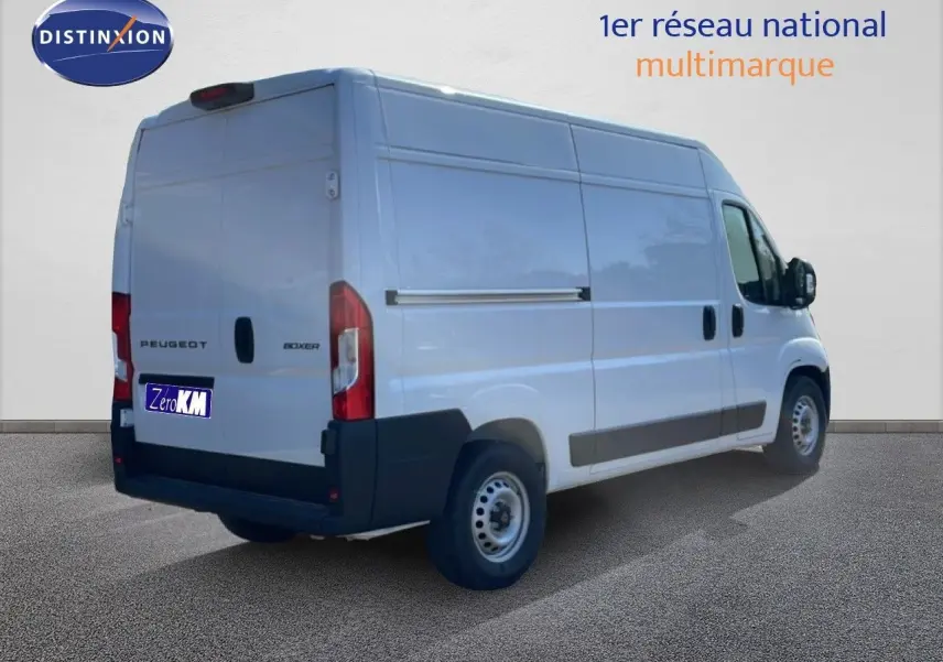 Vue 3/4 arrière droite d’un Peugeot Boxer Fourgon blanc banquise, avec portes arrière fermées et jantes acier simples.