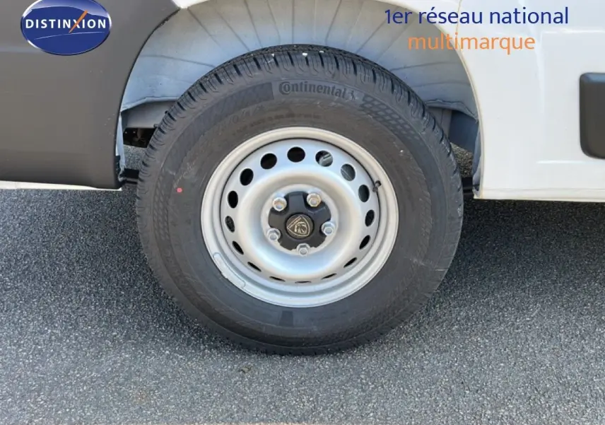 Gros plan sur la roue avant droite du Peugeot Boxer Fourgon blanc banquise, avec jante acier et pneu Continental.