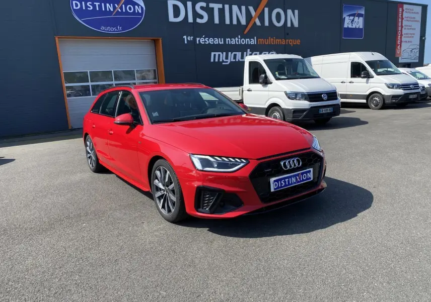 Audi A4 Avant S line rouge Tango vue 3/4 avant droit sur parking devant un bâtiment Distinxion.