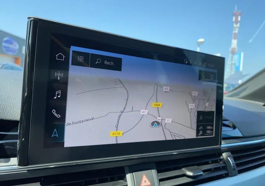 Écran central tactile montrant la navigation GPS dans l'habitacle d'une Audi A4 Avant rouge Tango de 2022.