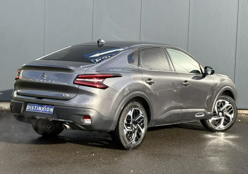 Vue 3/4 arrière droite d'une Citroën C4 X gris Platinium avec jantes alliage et feux LED distinctifs.