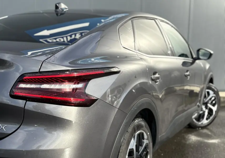 Vue 3/4 arrière droite d'une Citroën C4 X gris Platinium avec feux arrière LED et jantes alliage 18 pouces.