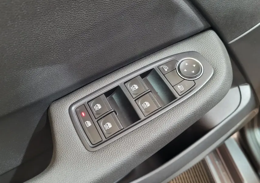 Commande des vitres électriques et réglage des rétroviseurs sur la porte avant gauche d'une Renault Clio gris foncé.